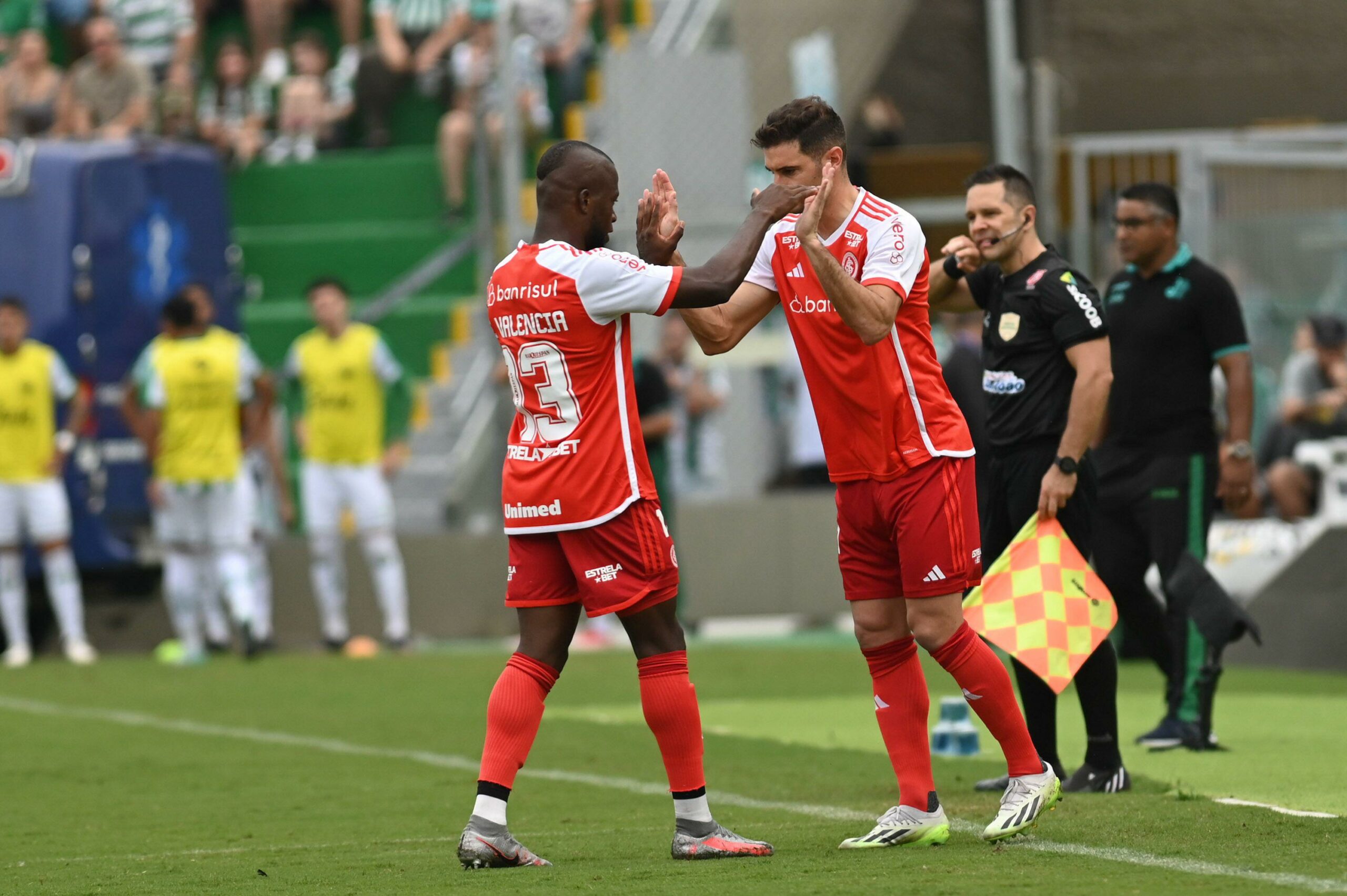 Dois jogadores do Sport Clube Internacional comemoram no campo após um gol na partida contra o Juventude.