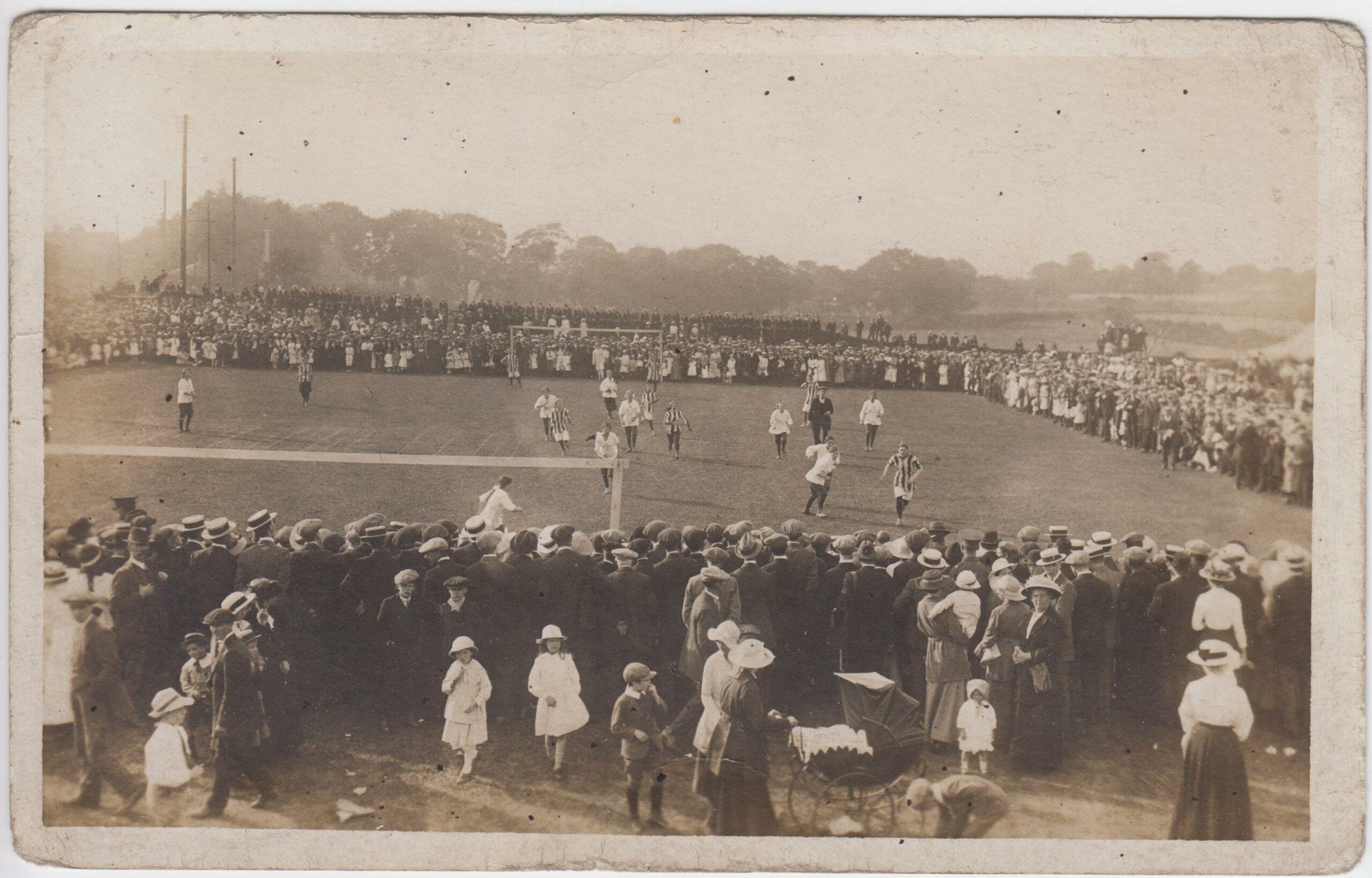 Women's football match in progress, being watched by a crowd, 1910s / 1920s, the location may be Winslow, Buckinghamshire