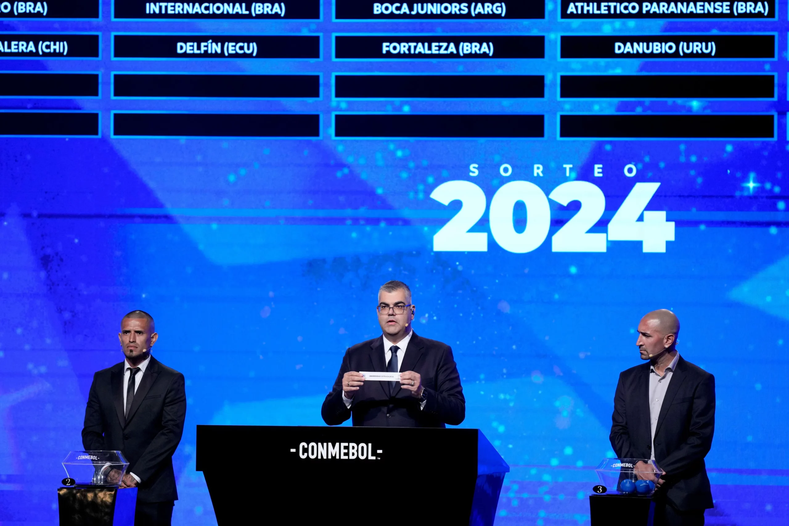 Competitions Director of Conmebol Frederico Nantes, center, holds a paper with the name of Ecuador"s Universidad Católica during the Copa Sudamericana draw in Luque, Paraguay, Monday, March 18, 2024.