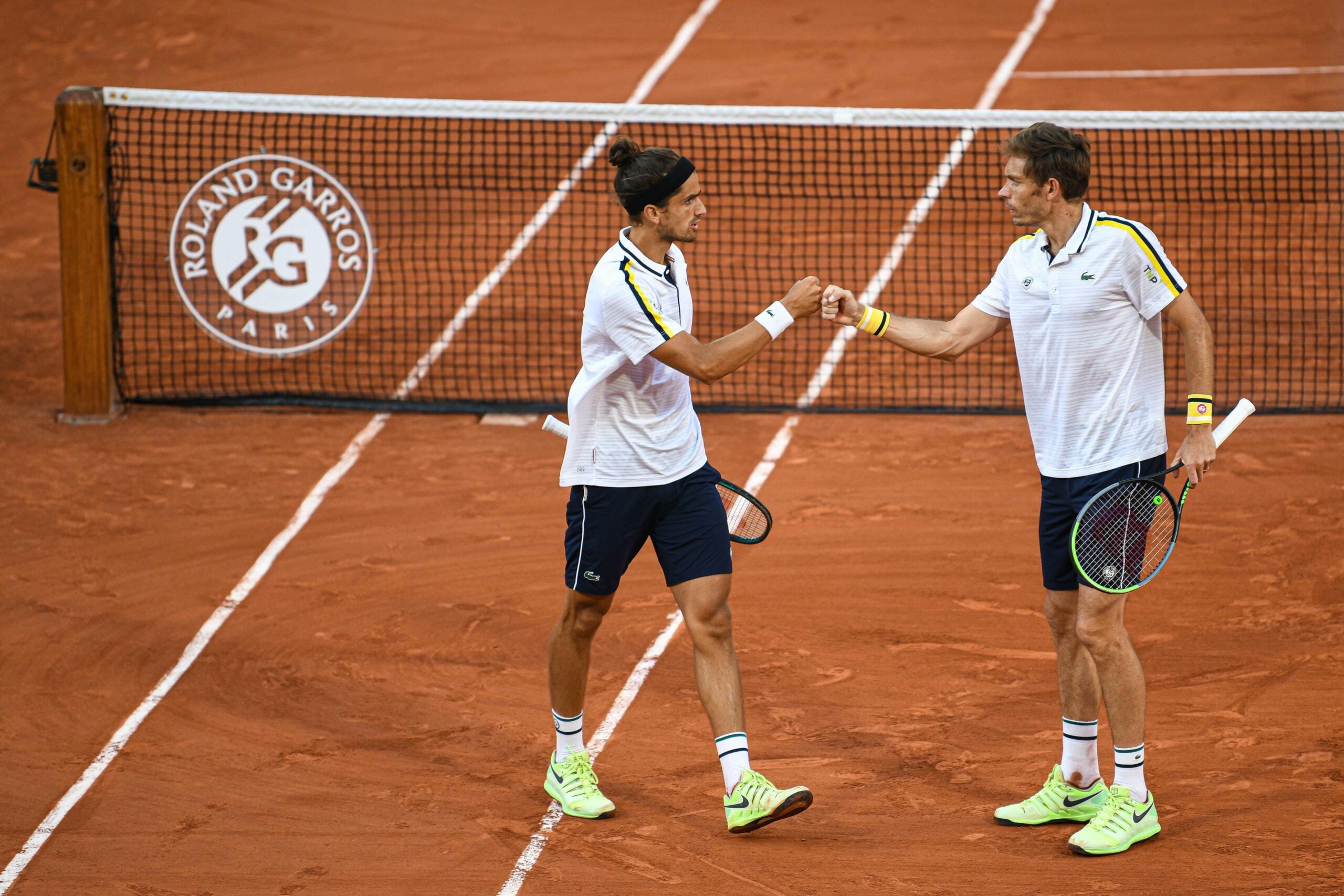 Atletas se cumprimentam em quadra durante partida do torneio Roland Garros em 2021.