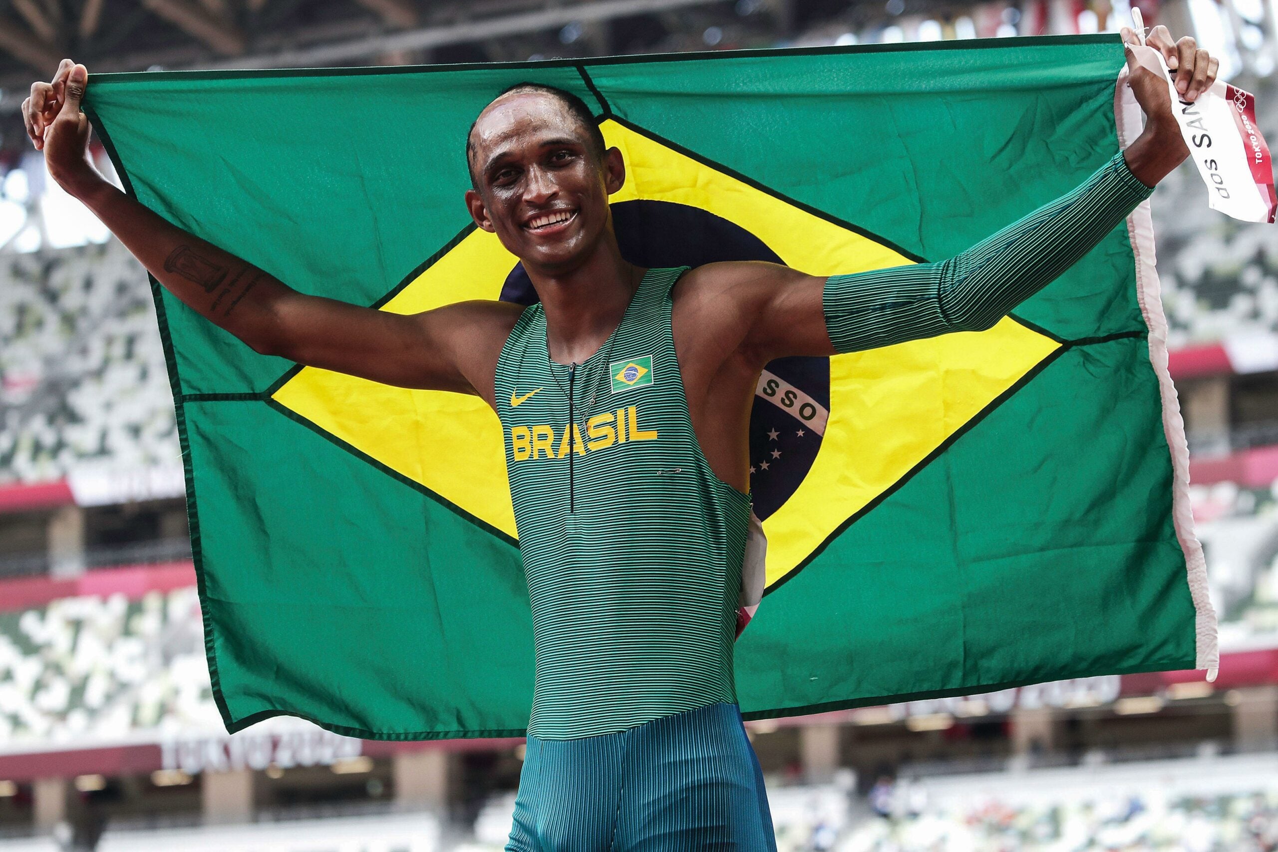 Alison dos Santos, atleta destaque nos 400 m, com bandeira do Brasil