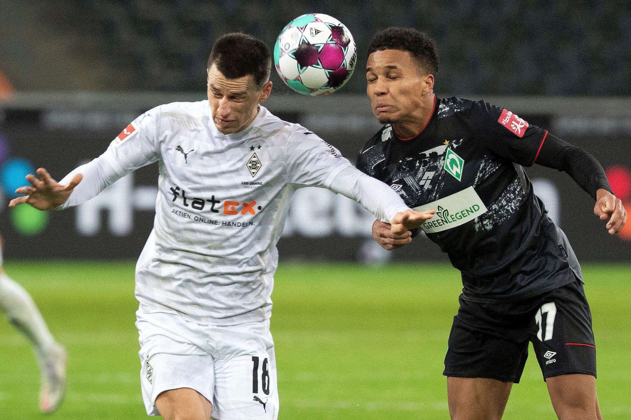 Monchengladbach's Stefan Lainer, left, and Bremen's Felix Agu battle for the ball during the Bundesliga soccer match between Borussia Monchengladbach and Werder Bremen at Borussia-Park in Monchengladbach, Germany, Tuesday Jan. 19, 2021. (Federico Gambarin