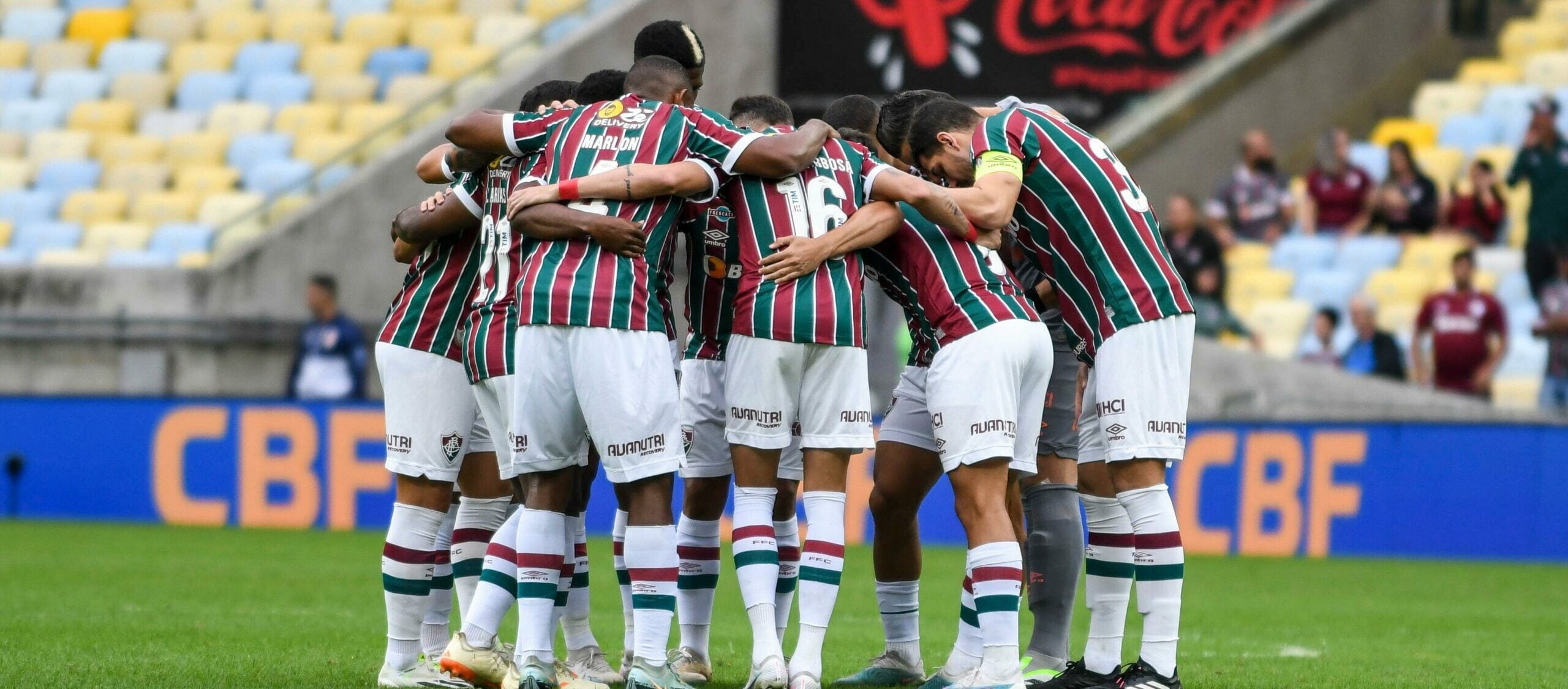 Equipe do Fluminense se abraça em campo durante partida no Maracanã