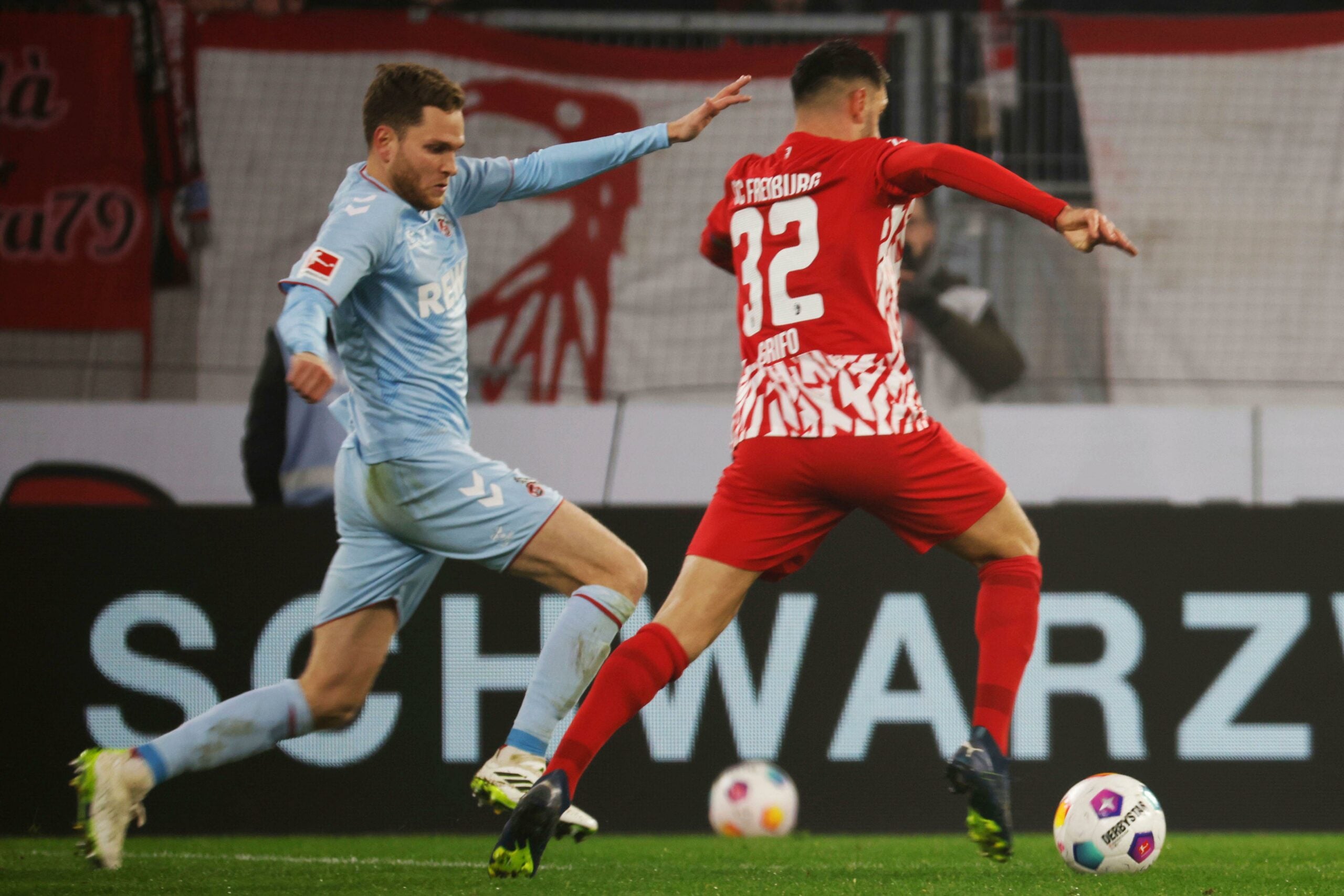 Cologne's Benno Schmitz, left, and Freiburg's Vincenzo Grifo battle for the ball during the Bundesliga soccer match between SC Freiburg and 1. FC Koln at Europa-Park Stadium, Freiburg, Germany, Sunday Dec. 17, 2023. (Philipp von Ditfurth/dpa via AP)
