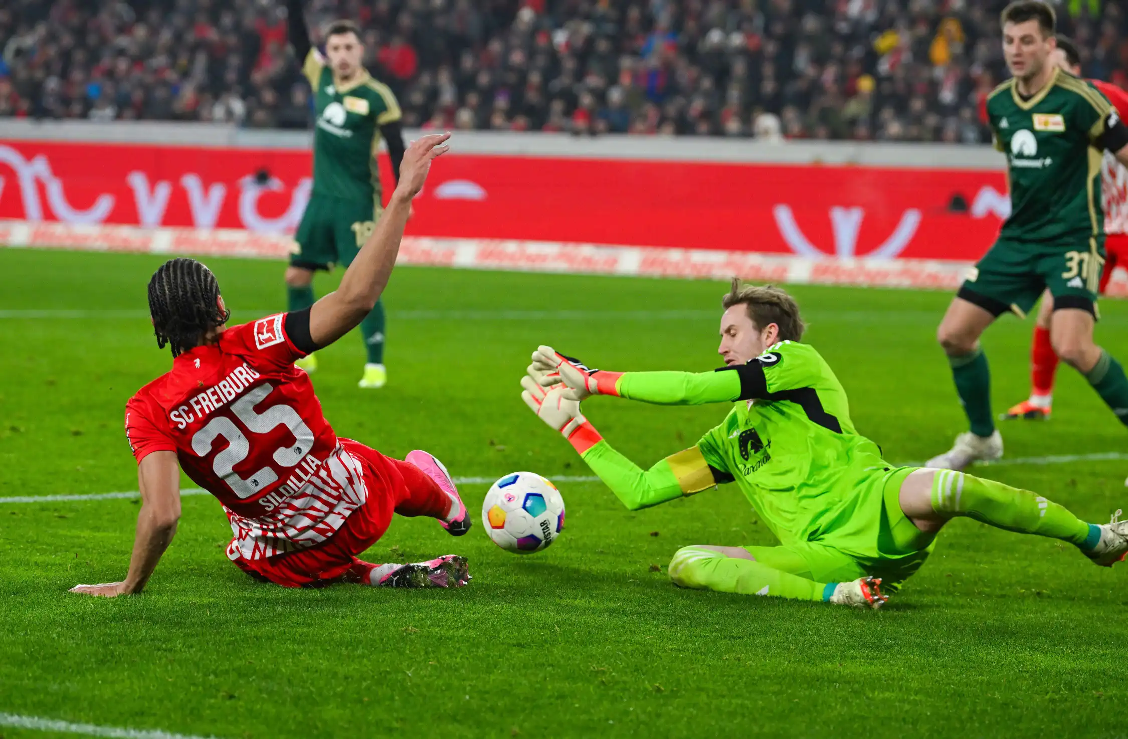 Goleiro Frederik Roennow (1. FC Union Berlin, #1) faz uma defesa contra Kiliann Sildillia (SC Freiburg, #25), GER, SC Freiburg vs. 1. FC Union Berlin