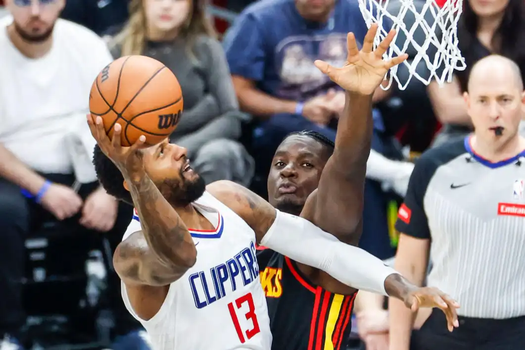 Paul George dos Los Angeles Clippers (à esquerda) vai para a cesta contra Clint Capela do Atlanta Hawks (à direita) durante uma partida de basquete da NBA