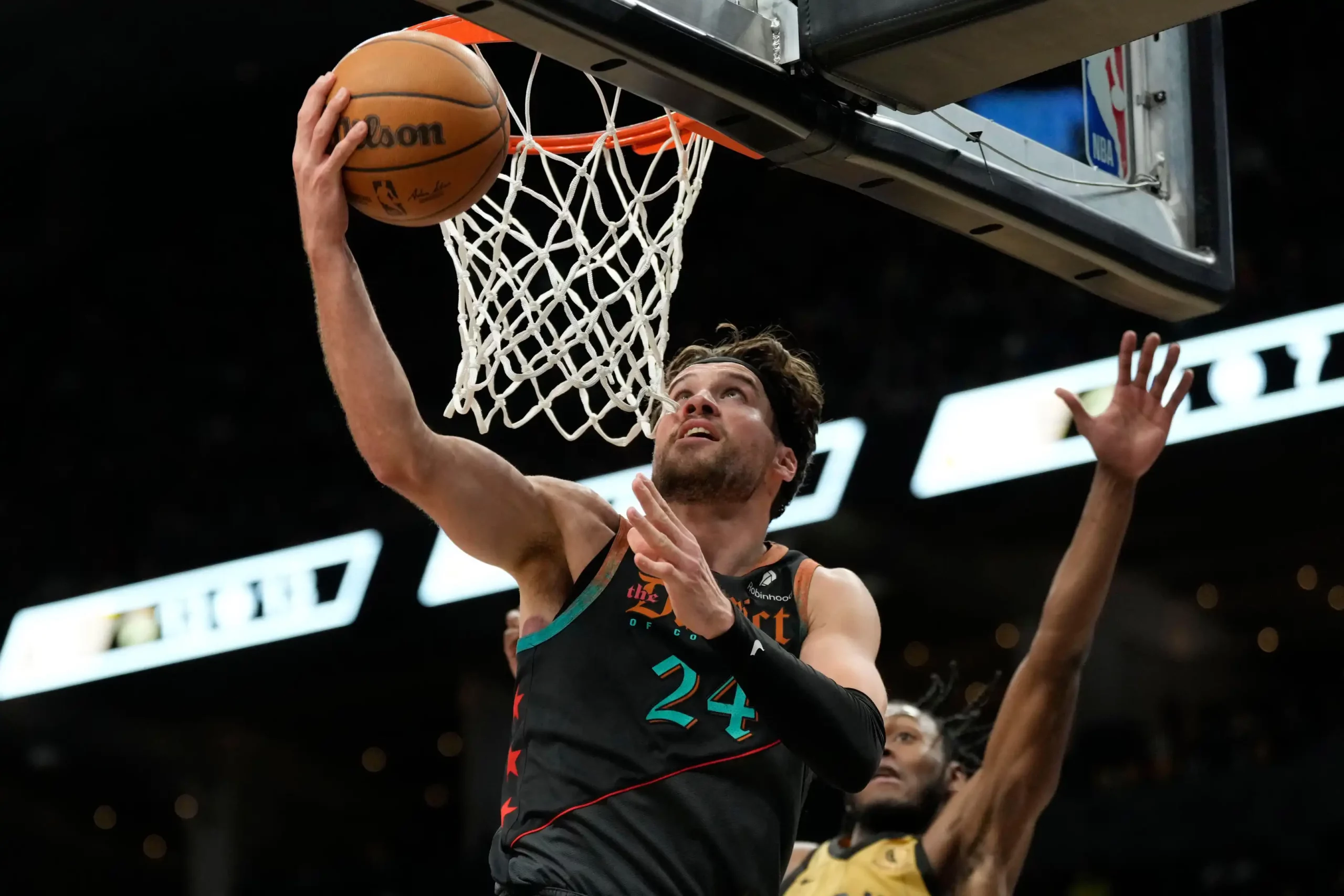 O ala do Washington Wizards, Corey Kispert (24), salta para a cesta enquanto o armador do Toronto Raptors, Immanuel Quickley (5), defende durante a segunda metade da partida de basquete da NBA em Toronto
