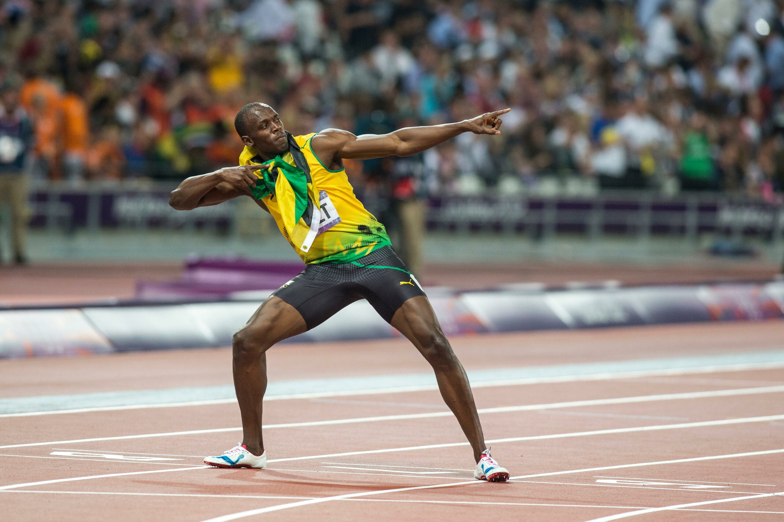 Usain Bolt, celebrando com sua icônica pose de arqueiro após uma vitória, vestindo o uniforme da Jamaica durante uma competição de atletismo em um estádio lotado.